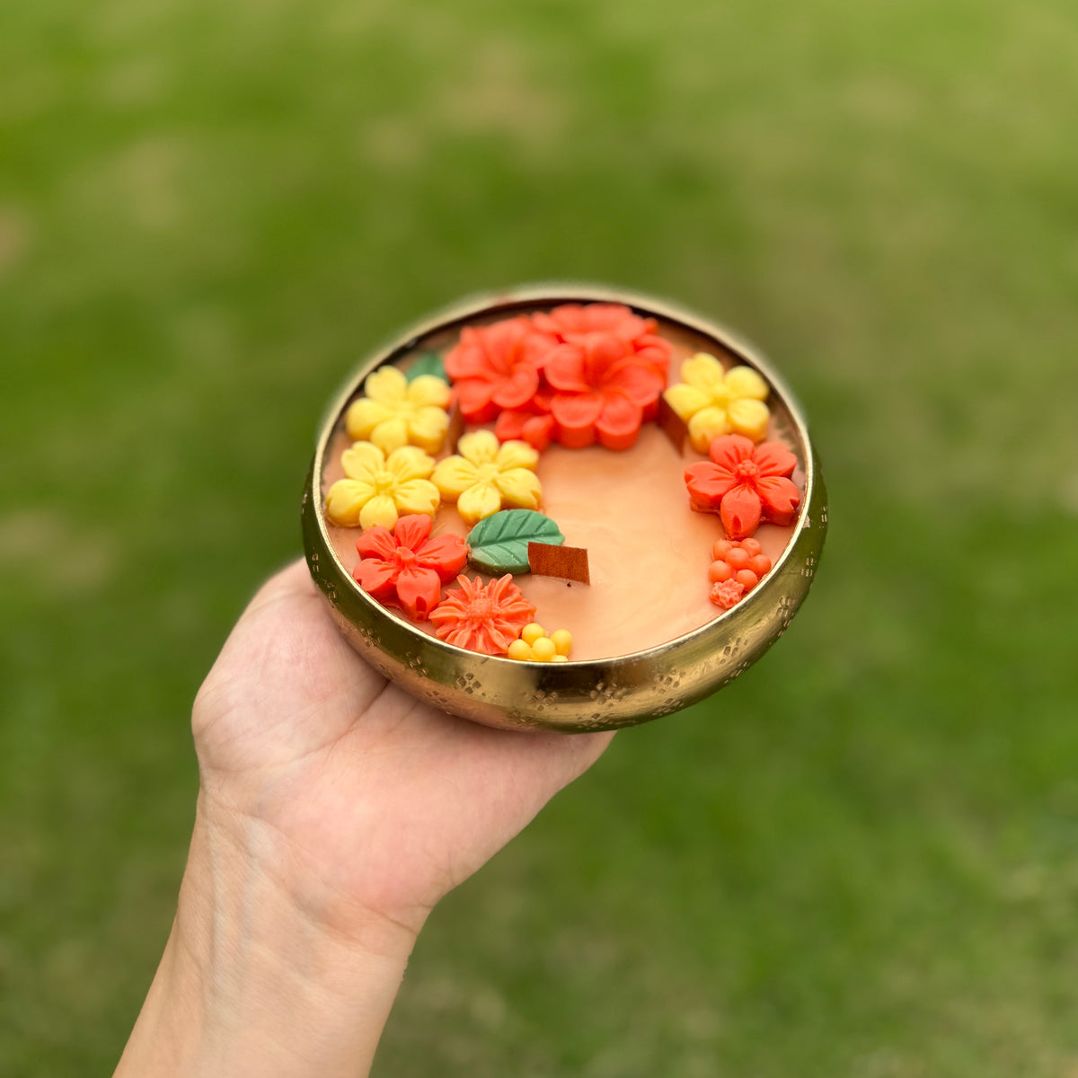 Hand holding a Utsav Floral Urli Candle
